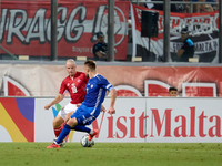 In Ta' Qali, Malta, on October 13, 2024, Trent Buhagiar of Malta is closely followed by Oleg Reabciuk of Moldova during the UEFA Nations Lea...