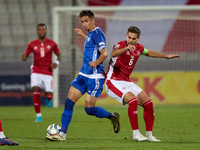 In Ta' Qali, Malta, on October 13, 2024, Mihail Caimacov of Moldova grapples for possession with Matthew Guillaumier of Malta during the UEF...