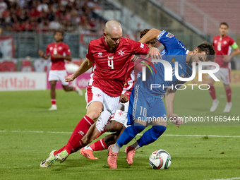 In Ta' Qali, Malta, on October 13, 2024, Gabriel Mentz of Malta vies for the ball with Vitalie Damascan of Moldova during the UEFA Nations L...