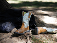 Boots rest against a tree as members of the Muwekma Ohlone Tribe of the San Francisco Bay Area, along with other tribal groups and their sup...