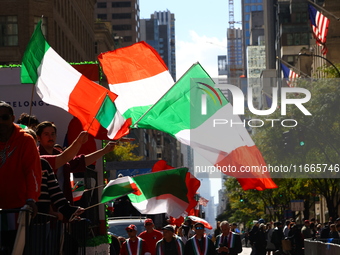 Participants wave flags as they march up 5th Avenue in the Columbus Day Parade in New York City, United States, on October 14, 2024. (