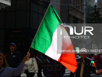 Participants wave flags as they march up 5th Avenue in the Columbus Day Parade in New York City, United States, on October 14, 2024. (