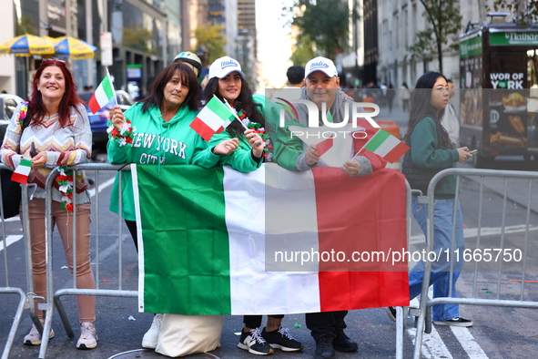 Spectators wave flags and show off Italian heritage as they march up 5th Avenue in the Columbus Day Parade in New York City, United States,...