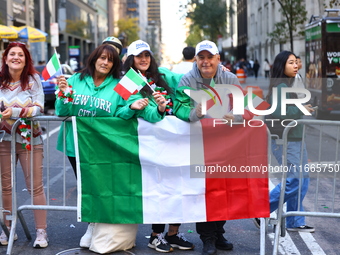 Spectators wave flags and show off Italian heritage as they march up 5th Avenue in the Columbus Day Parade in New York City, United States,...