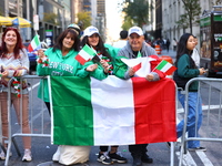 Spectators wave flags and show off Italian heritage as they march up 5th Avenue in the Columbus Day Parade in New York City, United States,...