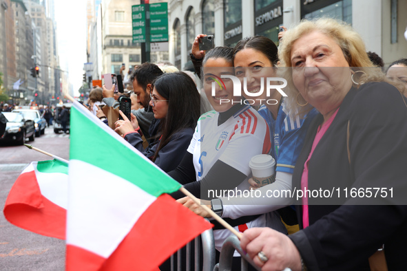 Spectators wave flags and show off Italian heritage as they march up 5th Avenue in the Columbus Day Parade in New York City, United States,...