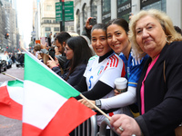 Spectators wave flags and show off Italian heritage as they march up 5th Avenue in the Columbus Day Parade in New York City, United States,...