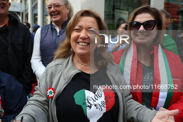 Spectators wave flags and show off Italian heritage as they march up 5th Avenue in the Columbus Day Parade in New York City, United States,...