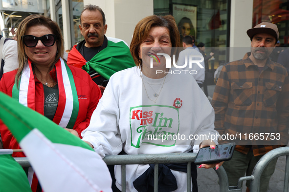 Spectators wave flags and show off Italian heritage as they march up 5th Avenue in the Columbus Day Parade in New York City, United States,...