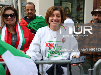 Spectators wave flags and show off Italian heritage as they march up 5th Avenue in the Columbus Day Parade in New York City, United States,...