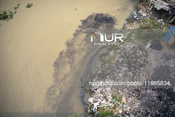 Water appears pitch black as industrial waste falls into the Shitalakkhya River in Dhaka, Bangladesh, on October 14, 2024. 