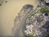 Water appears pitch black as industrial waste falls into the Shitalakkhya River in Dhaka, Bangladesh, on October 14, 2024. (