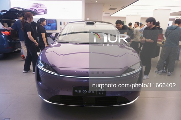 A customer watches a Huawei HIMA (Harmony Intelligent Mobility Alliance) LUXEED R7 in a Huawei store in Hangzhou, Zhejiang Province, China,...