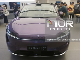 A customer watches a Huawei HIMA (Harmony Intelligent Mobility Alliance) LUXEED R7 in a Huawei store in Hangzhou, Zhejiang Province, China,...