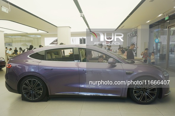 A customer watches a Huawei HIMA (Harmony Intelligent Mobility Alliance) LUXEED R7 in a Huawei store in Hangzhou, Zhejiang Province, China,...