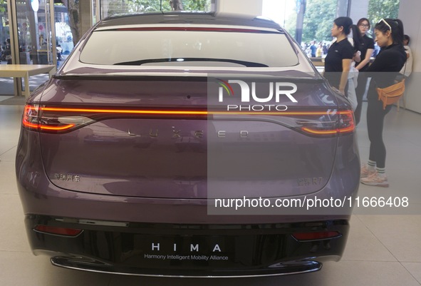 A customer watches a Huawei HIMA (Harmony Intelligent Mobility Alliance) LUXEED R7 in a Huawei store in Hangzhou, Zhejiang Province, China,...