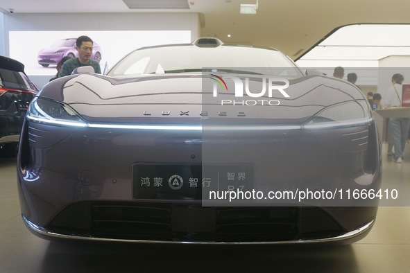 A customer watches a Huawei HIMA (Harmony Intelligent Mobility Alliance) LUXEED R7 in a Huawei store in Hangzhou, Zhejiang Province, China,...