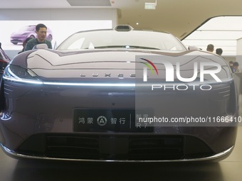 A customer watches a Huawei HIMA (Harmony Intelligent Mobility Alliance) LUXEED R7 in a Huawei store in Hangzhou, Zhejiang Province, China,...