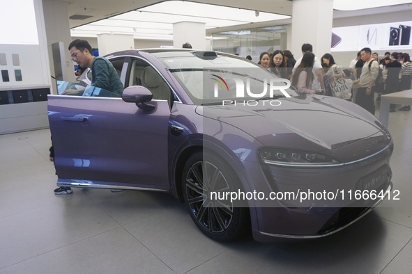 A customer watches a Huawei HIMA (Harmony Intelligent Mobility Alliance) LUXEED R7 in a Huawei store in Hangzhou, Zhejiang Province, China,...