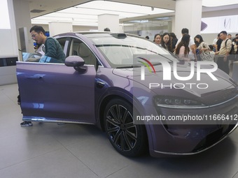 A customer watches a Huawei HIMA (Harmony Intelligent Mobility Alliance) LUXEED R7 in a Huawei store in Hangzhou, Zhejiang Province, China,...