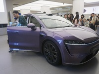 A customer watches a Huawei HIMA (Harmony Intelligent Mobility Alliance) LUXEED R7 in a Huawei store in Hangzhou, Zhejiang Province, China,...