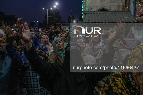 Kashmiri Muslim women raise their arms in prayer upon seeing a relic of Sheikh Abdul Qadir Jeelani, a Sufi saint, on his death anniversary o...