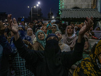 Kashmiri Muslim women raise their arms in prayer upon seeing a relic of Sheikh Abdul Qadir Jeelani, a Sufi saint, on his death anniversary o...