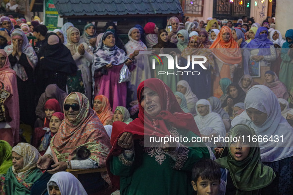 A Kashmiri Muslim woman prays upon seeing a relic of Sheikh Abdul Qadir Jeelani, a Sufi saint, on his death anniversary outside his shrine i...