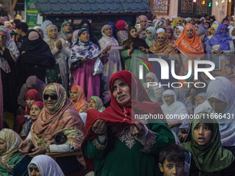 A Kashmiri Muslim woman prays upon seeing a relic of Sheikh Abdul Qadir Jeelani, a Sufi saint, on his death anniversary outside his shrine i...