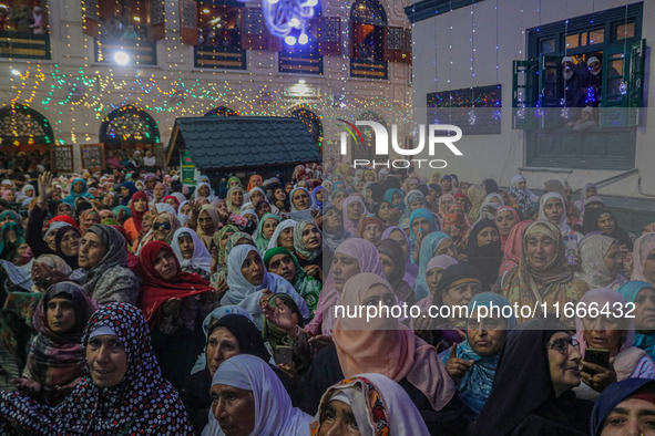 Kashmiri Muslim women pray upon seeing a relic of Sheikh Abdul Qadir Jeelani, a Sufi saint, on his death anniversary outside his shrine in S...