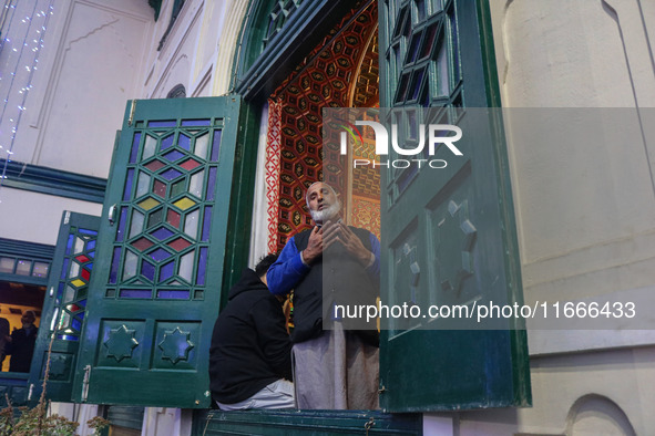 A Kashmiri Muslim man prays upon seeing a relic of Sheikh Abdul Qadir Jeelani, a Sufi saint, on his death anniversary outside his shrine in...