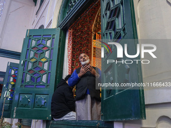 A Kashmiri Muslim man prays upon seeing a relic of Sheikh Abdul Qadir Jeelani, a Sufi saint, on his death anniversary outside his shrine in...