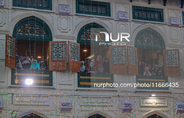 Kashmiri Muslim women raise their arms in prayer upon seeing a relic of Sheikh Abdul Qadir Jeelani, a Sufi saint, on his death anniversary o...