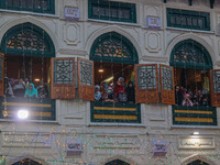 Kashmiri Muslim women raise their arms in prayer upon seeing a relic of Sheikh Abdul Qadir Jeelani, a Sufi saint, on his death anniversary o...