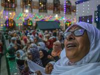 A Kashmiri Muslim woman prays upon seeing a relic of Sheikh Abdul Qadir Jeelani, a Sufi saint, on his death anniversary outside his shrine i...