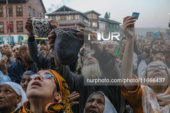 Kashmiri Muslims raise their arms in prayer upon seeing a relic of Sheikh Abdul Qadir Jeelani, a Sufi saint, on his death anniversary outsid...