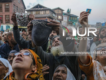 Kashmiri Muslims raise their arms in prayer upon seeing a relic of Sheikh Abdul Qadir Jeelani, a Sufi saint, on his death anniversary outsid...