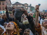 Kashmiri Muslims raise their arms in prayer upon seeing a relic of Sheikh Abdul Qadir Jeelani, a Sufi saint, on his death anniversary outsid...