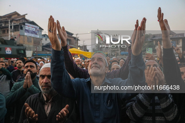 Kashmiri Muslims raise their arms in prayer upon seeing a relic of Sheikh Abdul Qadir Jeelani, a Sufi saint, on his death anniversary outsid...