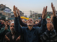 Kashmiri Muslims raise their arms in prayer upon seeing a relic of Sheikh Abdul Qadir Jeelani, a Sufi saint, on his death anniversary outsid...