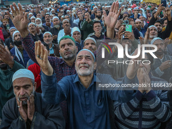 Kashmiri Muslims raise their arms in prayer upon seeing a relic of Sheikh Abdul Qadir Jeelani, a Sufi saint, on his death anniversary outsid...