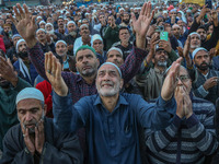 Kashmiri Muslims raise their arms in prayer upon seeing a relic of Sheikh Abdul Qadir Jeelani, a Sufi saint, on his death anniversary outsid...