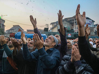 Kashmiri Muslims raise their arms in prayer upon seeing a relic of Sheikh Abdul Qadir Jeelani, a Sufi saint, on his death anniversary outsid...