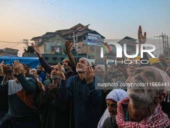 Kashmiri Muslims raise their arms in prayer upon seeing a relic of Sheikh Abdul Qadir Jeelani, a Sufi saint, on his death anniversary outsid...