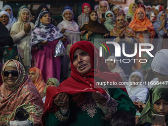 A Kashmiri Muslim woman prays upon seeing a relic of Sheikh Abdul Qadir Jeelani, a Sufi saint, on his death anniversary outside his shrine i...