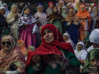 A Kashmiri Muslim woman prays upon seeing a relic of Sheikh Abdul Qadir Jeelani, a Sufi saint, on his death anniversary outside his shrine i...