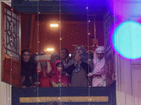 Kashmiri Muslim women raise their arms in prayer upon seeing a relic of Sheikh Abdul Qadir Jeelani, a Sufi saint, on his death anniversary o...