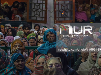 Kashmiri Muslim women raise their arms in prayer upon seeing a relic of Sheikh Abdul Qadir Jeelani, a Sufi saint, on his death anniversary o...