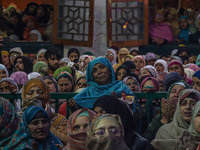 Kashmiri Muslim women raise their arms in prayer upon seeing a relic of Sheikh Abdul Qadir Jeelani, a Sufi saint, on his death anniversary o...