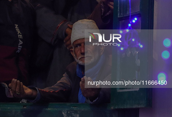 A Kashmiri Muslim man prays upon seeing a relic of Sheikh Abdul Qadir Jeelani, a Sufi saint, on his death anniversary outside his shrine in...